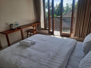 a bed in a room with a large window at L'JAVAS VILLAS in Kalibendo
