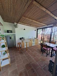 Casa Mapache في تاماريندو: مطبخ وغرفة طعام مع طاولة وكراسي