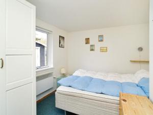 ein Schlafzimmer mit einem Bett mit blauen Kissen darauf in der Unterkunft Holiday home Højby III in Højby