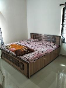 a large wooden bed in a room at Agarwal Guest House in Naya Raipur