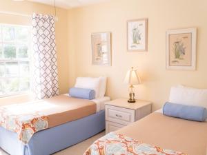 1 dormitorio con 2 camas y ventana en Perfect Island Retreat at Paradise Island Beach Club Villas en Creek Village