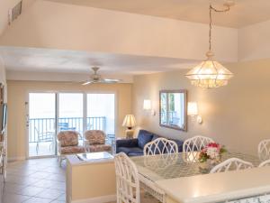 a dining room and living room with a table and chairs at Perfect Island Retreat at Paradise Island Beach Club Villas in Creek Village