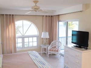 a bedroom with a bed and a tv and a window at Perfect Island Retreat at Paradise Island Beach Club Villas in Creek Village
