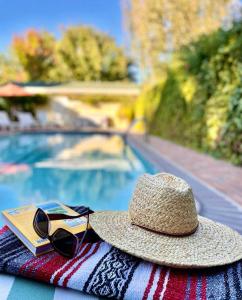 a straw hat and sunglasses sitting on a towel next to a swimming pool at Tallman Hotel in Upper Lake