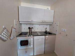 a small kitchen with white cabinets and a microwave at Appartement Autrans, 3 pièces, 6 personnes - FR-1-737-64 in Autrans