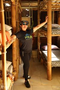 a woman standing in a room with bunk beds at Pousada nascente das aguas in Paranaguá