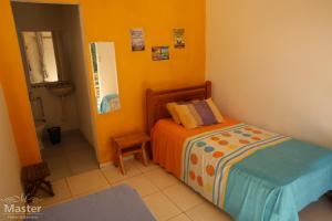 a small bedroom with a bed and a bathroom at Pousada nascente das aguas in Paranaguá