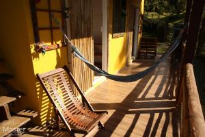 a hammock on the porch of a house at Pousada nascente das aguas in Paranaguá