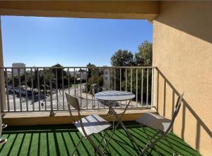 a patio with a table and chairs on a balcony at Confortable Appartement près d'AVIGNON in Le Pontet
