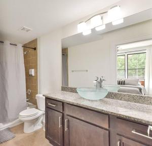 ein Badezimmer mit einem Waschbecken, einem WC und einem Spiegel in der Unterkunft Modern rooftop home in Midtown in Atlanta