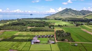 an aerial view of a house in a field next to the water at NammNatawn2 in Ko Yao Noi