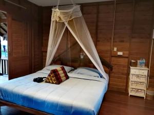 a bed with a canopy in a room at NammNatawn2 in Ko Yao Noi