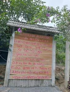 a sign with writing on it in front of a tree at La Bằng Homestay in Lá Cam
