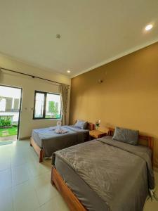 a bedroom with two beds and a window at ARECA MUINE HOMESTAY in Phan Thiet