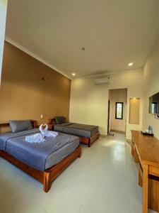 a bedroom with two beds and a desk at ARECA MUINE HOMESTAY in Phan Thiet