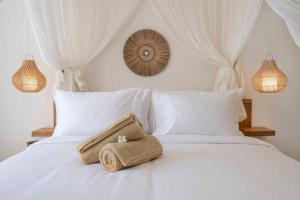 uma toalha sentada em cima de uma cama branca em ARTI by Umah - Pererenan em Canggu
