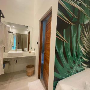 un bagno con un grande lavandino e un grande specchio di Bahandi Hotel a General Luna