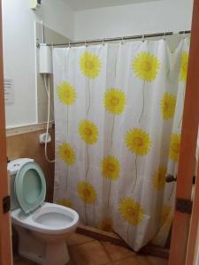 baño con cortina de ducha con flores amarillas en WJV INN JY, en Cebú