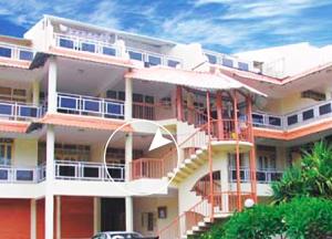 un grande edificio bianco con delle scale di fronte di Lovely 2-bedroom condo close to the beach… a Trou aux Biches