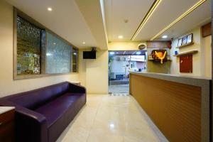 a lobby with a purple couch and a bar at Hotel Diamora Residency in Thane