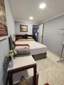 ein Schlafzimmer mit 2 Betten und einem Tisch mit Blumen in der Unterkunft Loft 37 Centro histórico in São Paulo