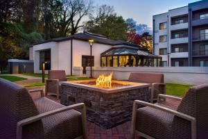 a fire pit in a yard with chairs and a building at Courtyard by Marriott Rye in Rye