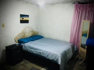 Un dormitorio con una cama con almohadas azules. en Alojamiento en Cholula, en Cholula