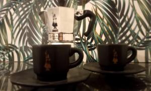 zwei Kaffeetassen auf einem Tisch neben einer Pflanze in der Unterkunft Casa Antigua 'LEON' in Mendoza