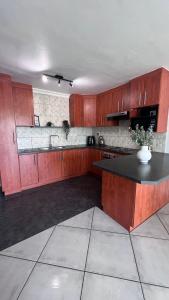 a kitchen with wooden cabinets and a black counter top at Family Holiday Home Rental in Port Elizabeth in Lorraine
