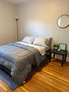 a bed in a room with a table and a mirror at *Cozy, Convenient Boston. Indulge, you deserve it* in Boston