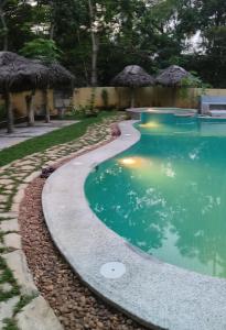 a swimming pool with a path around it at Marari Beach Bungalow in Mararikulam