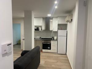 uma cozinha com um sofá e um frigorífico branco em Apartamento Centro em Rubí