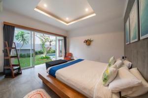 a bedroom with a large bed and a large window at Villa Gemuk in Seminyak