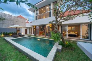 an external view of a house with a swimming pool at Villa Gemuk in Seminyak