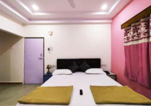 um quarto com uma cama grande com paredes cor-de-rosa e roxo em Hotel Mina Palace Wardha em Wardha