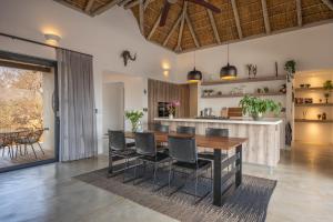a kitchen and dining room with a wooden table and chairs at Villa Lanterfant - luxury stay in nature - solar powered in Hoedspruit