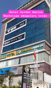 a building with a sign for a hotel at GOLDEN AMULYA REST WINGS in Yelahanka