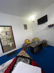 a room with a bed and a tv on the wall at Goonkeshari Homestay in Ghum +47 photos