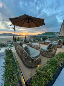 a patio with chairs and tables and an umbrella at Coron 180 Hotel in Coron