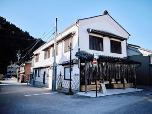 een wit gebouw met een winkel aan de voorkant met ingehouden dvd's bij 小鳩屋 in Asuke-chō