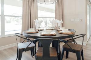 Un comedor con una mesa con sillas y una lámpara de araña. en Sovanita House Naples, FL, en Naples