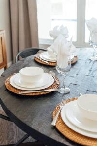 una mesa de madera con placas blancas y gafas. en Sovanita House Naples, FL, en Naples 30 fotos más
