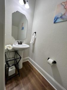 a white bathroom with a sink and a mirror at Daisy's Luxury Home in San Antonio