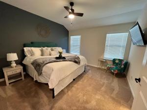 a bedroom with a bed and a ceiling fan at Daisy's Luxury Home in San Antonio