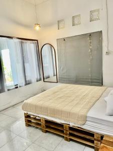 een groot bed in een kamer met ramen bij Old Style Surf Apartment with Private Kitchen and Shared Pool Canggu in Canggu