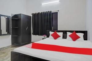 a bedroom with a large bed with red pillows at Flagship Well Quest Palace Private Limited in Patna