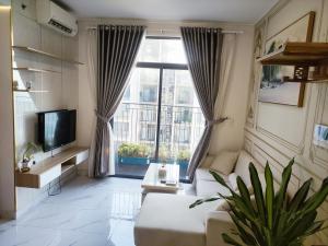 een woonkamer met een bank en een groot raam bij Chung cư cao cấp Asiana Capella quận 6 in Ho Chi Minh-stad