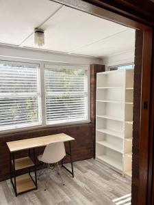 Zimmer mit einem Schreibtisch und 2 Fenstern in der Unterkunft Study/Sun room attached MQ Park/Uni/Eastwood/Ryde Spacious room in Sydney