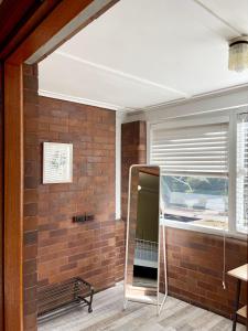 Zimmer mit Ziegelwand und Spiegel in der Unterkunft Study/Sun room attached MQ Park/Uni/Eastwood/Ryde Spacious room in Sydney