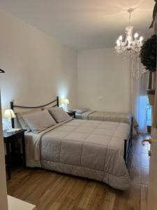 a bedroom with two beds and a chandelier at Il Castello di Alberico in Cotignola